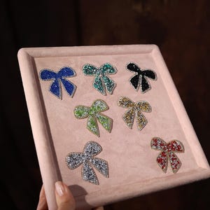 a person holding a tray with different colored bows on it
