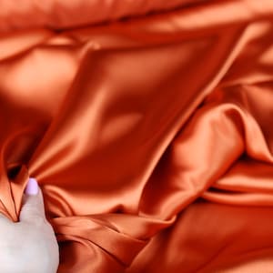 Tela de satén charmeuse color naranja óxido: ideal para novias, disfraces y drapeados; se corta a medida.