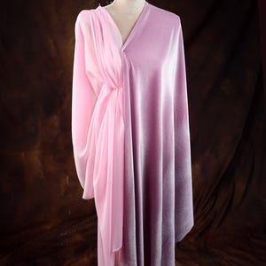 A mannequin wearing a pink satin dress with a draped, flowing skirt.