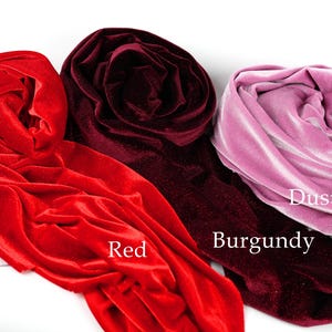 three different colored velvet fabrics: red, burgundy, and dusty pink.