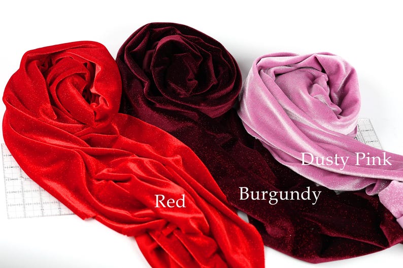 three different colored velvet fabrics: red, burgundy, and dusty pink.