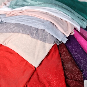 a pile of clothes sitting on top of a bed