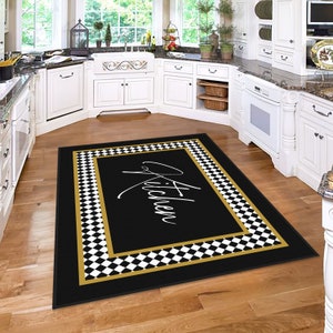 Puede incluir: Alfombra de cocina a cuadros negros y blancos con borde dorado y la palabra "Cocina" escrita en blanco.