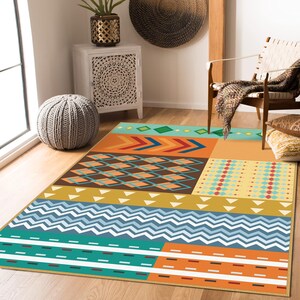 May include: A rectangular area rug featuring a multi-colored geometric pattern. The design includes sections of teal, orange, yellow, and brown, with repeating motifs such as chevrons, diamonds, zigzags, and horizontal stripes across the surface.