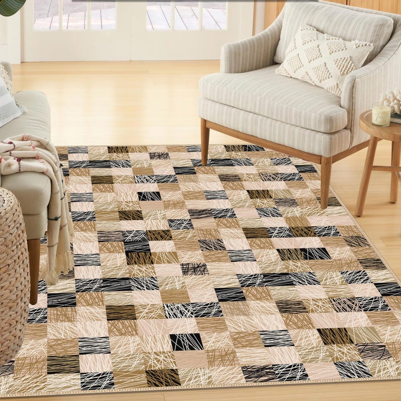 May include: A rectangular rug with a geometric patchwork design. The rug features squares in beige, brown, and black, with white linear accents. It's placed on a light wooden floor, with furniture visible in the background. The rug's dimensions are suitable for a living room.
