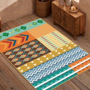 May include: A rectangular area rug featuring a patchwork design of geometric patterns in shades of teal, orange, brown, yellow, and white. The rug displays sections of chevrons, diamonds, stripes, zigzags, and small squares across its surface.