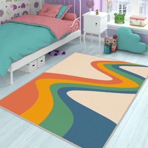 May include: A colorful rug with a wavy rainbow design in shades of orange, yellow, green, blue, and cream. The rug is on a light blue wooden floor.