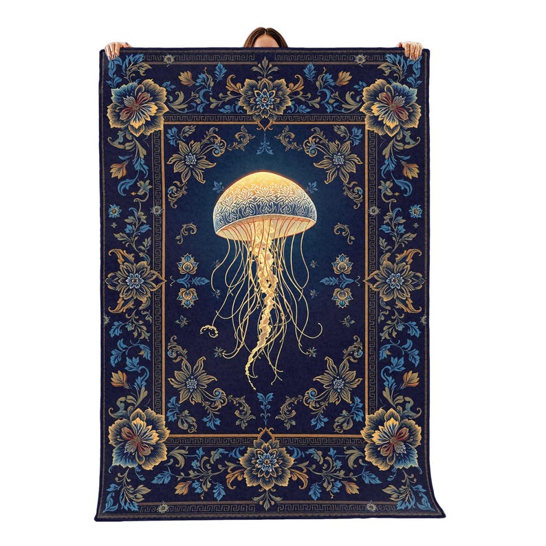 May include: A rectangular throw blanket featuring a central glowing jellyfish with long, trailing tentacles against a deep navy blue background. The border displays an intricate floral pattern in shades of gold, light blue, and dark blue.