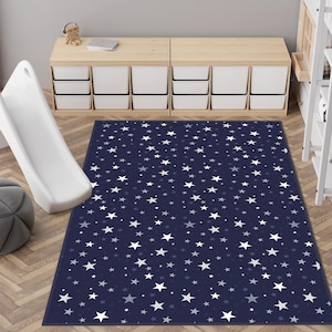 Könnte beinhalten: Ein marineblauer Teppich mit einem weißen Sternenmuster. Der Teppich befindet sich in einem Raum mit einer weißen Rutsche und einem Holzschrank.