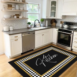 Puede incluir: Alfombra de cocina a cuadros negros y blancos con borde dorado y la palabra "Cocina" escrita en cursiva blanca.
