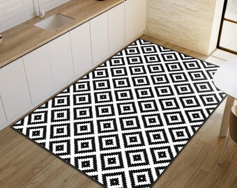 May include: A rectangular area rug featuring a repeating black and white geometric pattern of nested squares. The design consists of alternating black and white borders arranged in a grid, creating a high-contrast visual effect across the entire surface.