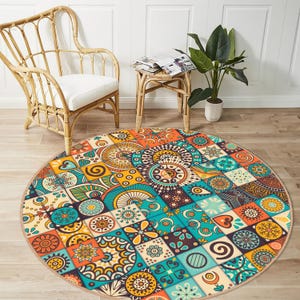Könnte beinhalten: Ein runder, bunter Teppich mit Patchwork-Muster, das verschiedene geometrische Formen und Muster in Blautönen, Orange, Gelb und Braun zeigt.