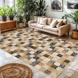 May include: A rectangular rug with a patchwork design in beige, brown, and black. The rug features solid squares and squares with linear patterns. A round, woven rug is in the foreground. The rug is suitable for a living room.