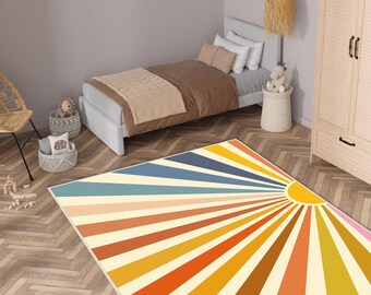May include: A colorful rug with a sunburst design in shades of yellow, orange, red, blue, and green. The rug has a white background and is perfect for a child's room or play area.