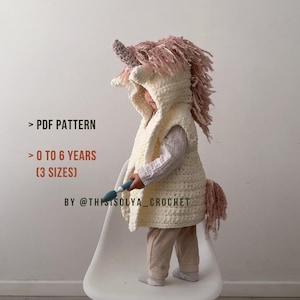 May include: A white crocheted unicorn vest with a pink mane and tail. The vest has a hood and is designed for children ages 0 to 6 years. The pattern is available in three sizes.  > PDF PATTERN > 0 TO 6 YEARS [3 SIZES] BY @THISISOLYA_CROCHET