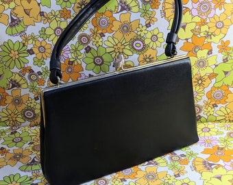 Black small vintage handbag with fancy clasp.