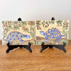Set mit 2 Vintage handbemalten Portugal Kunst Fliesen mit Blau Schildkröte Motiv, botanisches Detail, signiert Bert, beige Keramik Wanddekor