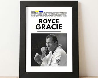 May include: A framed black and white print featuring Royce Gracie. The print includes the name "Royce Gracie" in large, bold letters above a black and white photo of Gracie in a martial arts uniform. Text at the top provides biographical information.