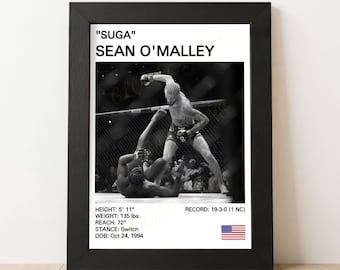 May include: Black framed print featuring a black and white action shot of a mixed martial arts fight. The print includes the text "SUGA" SEAN O'MALLEY, along with stats: height 5' 11", weight 135 lbs, reach 72", and record 19-3-0 (1 NC).
