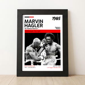 Op de afbeelding: Ingelijste zwart-wit boks poster met Marvin Hagler en Thomas Hearns in een Middleweight Title Fight. De poster bevat het jaar 1985, de locatie en het prijzengeld.