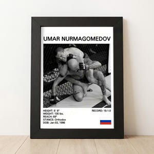 Puede incluir: Impresión en blanco y negro enmarcada de Umar Nurmagomedov en un combate de la UFC. La impresión incluye el nombre del luchador, altura (1,73 m), peso (61 kg), alcance (175 cm), postura, fecha de nacimiento y récord (18-1-0).
