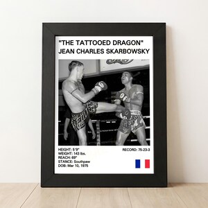 Könnte beinhalten: Schwarz-Weiß-Druck in einem Rahmen mit einer Muay Thai-Kampfszene. Der Druck enthält den Text "THE TATTOOED DRAGON" und "JEAN CHARLES SKARBOWSKY". Zusätzlicher Text gibt Größe, Gewicht, Reichweite, Kampfstellung, Geburtsdatum und Bilanz des Kämpfers an.