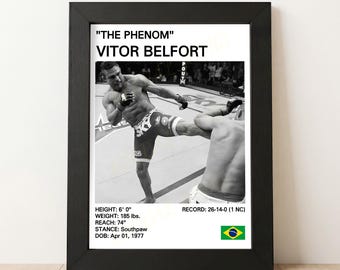 May include: Black framed print featuring a black and white action shot of Vitor Belfort in a mixed martial arts fight. The print includes text with Belfort's height, weight, reach, stance, and date of birth. The Brazilian flag is in the lower right corner.