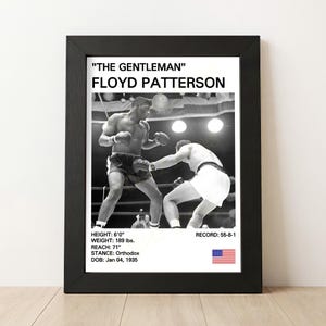 May include: Black framed print featuring a black and white photograph of boxer Floyd Patterson in action. The print includes Patterson's name, nickname, height, weight, reach, stance, date of birth, and record. An American flag is in the lower right corner.