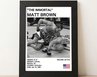 May include: Black framed print featuring a black and white image of a mixed martial arts fight. The print includes the text "THE IMMORTAL" MATT BROWN, fighter stats: 6' 0" height, 170 lbs weight, 75" reach, and a record of 26-19-0.