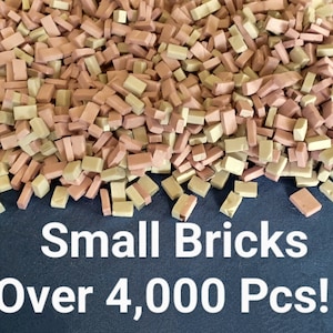 May include: A large pile of over 4,000 small, rectangular bricks in two colors: light brown and pink. The bricks are scattered on a blue surface.
