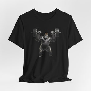 May include: Black t-shirt with a graphic of a gorilla lifting a barbell.