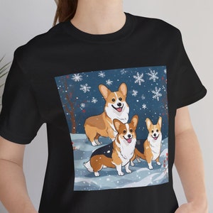 Cartoon Corgi Dogs Winter Unisex Tee, prezent dla miłośników psów, świąteczna koszulka świąteczna, śnieżna scena, świąteczna koszulka
