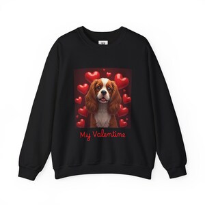May include: Black sweatshirt with a graphic of a Cavalier King Charles Spaniel surrounded by red hearts. The text "My Valentine" is printed below the image.