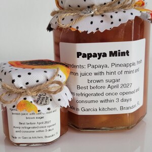 May include: Two jars of Papaya Mint jam with fabric-covered lids and twine ties. Labels detail ingredients and a 'best before' date. The smaller jar has a 'Made with Love' tag. The jars are filled with a brown preserve.