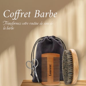 May include: A wooden beard comb with the name "Laurent" engraved on it, a boar bristle brush, a pair of small scissors, and a gray velvet pouch. The text "Coffret Barbe" and "Transformez votre routine de soin de la barbe" is visible in the image.