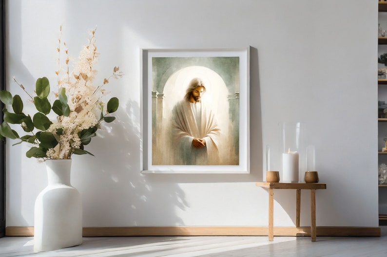 May include: A painting of Jesus Christ wearing a white robe, standing in a light-filled room with pillars. The painting is framed in a white frame and hangs on a white wall.