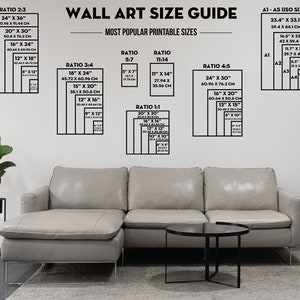 May include: A wall art size guide with different ratios and measurements in inches and centimetres. The guide shows the most popular printable sizes for wall art. The image also includes a sectional sofa with a light grey fabric.