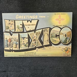 May include: Vintage postcard with the words "Greetings from New Mexico" in large letters. The postcard features illustrations of New Mexico landmarks and the Zia Sun Symbol. The text "The Sunshine State" is also present.