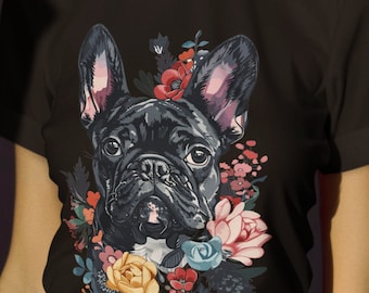 May include: A black t-shirt with a floral print featuring a French bulldog. The bulldog is wearing a flower crown and the flowers are in shades of pink, yellow, red, and blue.