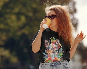 May include: A woman wearing a black t-shirt with a colorful chihuahua and floral print. She is holding a brown paper cup and wearing sunglasses.