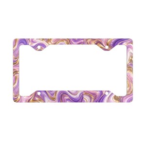 May include: A rectangular number plate surround featuring a swirling marble pattern in shades of purple, lavender, and white, accented with metallic gold veins. The frame has four circular mounting holes positioned at the corners for attachment.