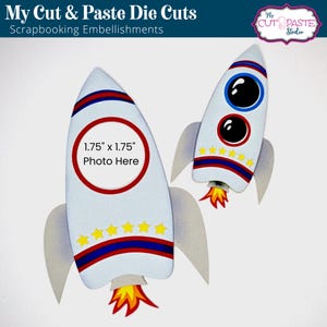 May include: Two rocket-shaped die cuts for scrapbooking. The larger rocket has a 1.75 inch by 1.75 inch circle for a photo. Both rockets have red, white, and blue stripes, yellow stars, and a flame coming out of the bottom.