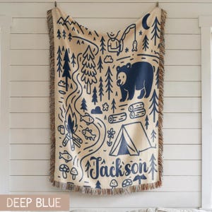 Woodland camping nursery blanket featuring fishing, tent, trees and outdoor adventure design, perfect rustic kids room decor.