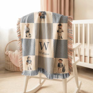 May include: A woven throw blanket featuring a checkered pattern of cream and blue-grey panels. The design includes illustrations of teddy bears dressed in various sports uniforms, the letter W, and the name William in a dark blue script font.