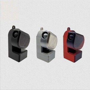 Puede incluir: Tres peque&ntilde;os altavoces de pared impresos en 3D en negro, gris y rojo.