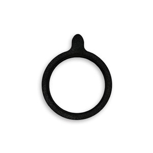 May include: A circular black gasket with a textured surface and a small, rounded tab extending from the top edge. The object features a hollow center and a consistent, uniform thickness throughout its entire ring-shaped structure.
