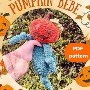 Puede incluir: Patrón de crochet para un juguete amigurumi en forma de calabaza. El patrón está disponible para descargar en PDF. La imagen muestra un juguete de crochet en forma de calabaza con un cuerpo turquesa y una cabeza naranja. El juguete está sentado en un lecho de musgo verde. El texto "Pumpkin Bebe Crochet Lovey PDF pattern" es visible en la imagen.