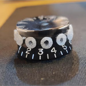May include: Black guitar knob with white numbers 1 to 6 and white dots around the edge.