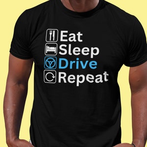 May include: A black t-shirt with white text that reads "Eat Sleep Drive Repeat". The word "Drive" is in blue and features a steering wheel icon.
