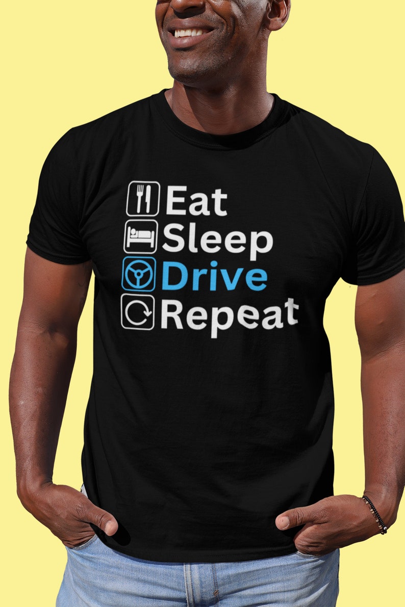 May include: A black t-shirt with white text that reads "Eat Sleep Drive Repeat". The word "Drive" is in blue and features a steering wheel icon.